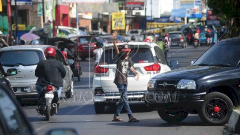 Salah satu 'pak ogah' yang kerap berada di putaran jalan (U Turn) di sejumlah ruas jalan di Kota Makassar.