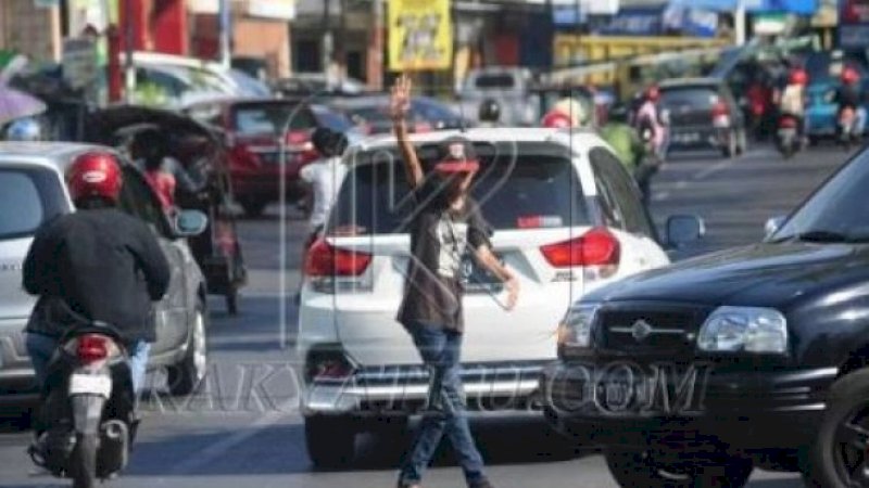 Pak Ogah yang beroperasi di salah satu ruas jalan Kota Makassar.
