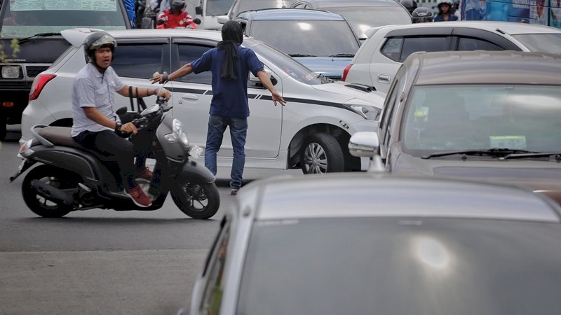 Penampakan Pak Ogah saat mengatur kendaraan di Jalan Urip Sumoharjo. (Foto/Arfa).