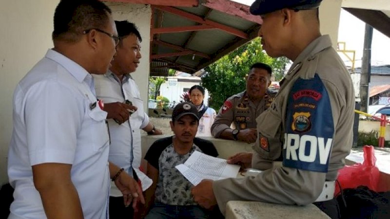 Ardi (baju hitam), jukir liar saat digiring ke Mako Brimob Makassar, Kamis (10/1/2019).