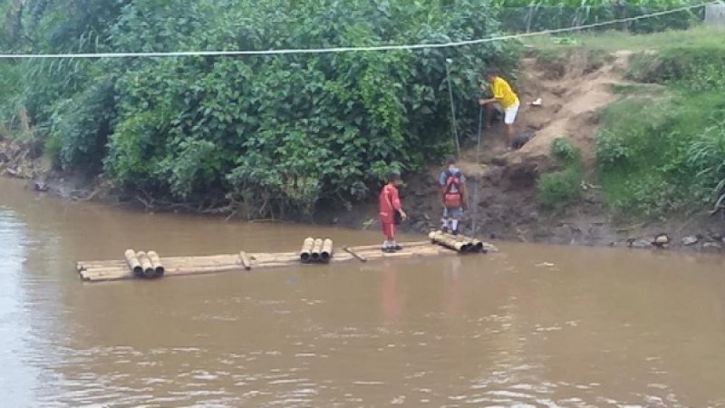 Siswa menyeberang sungai dengan menggunakan rakit.