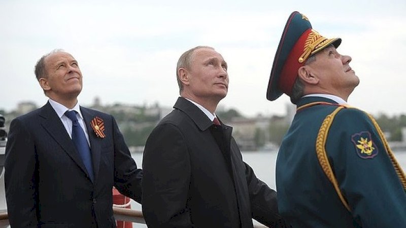 Aleksandr Bortnikov, direktur FSB, di sebelah Vladimir Putin dan Sergey Shoigu, menteri pertahanan.