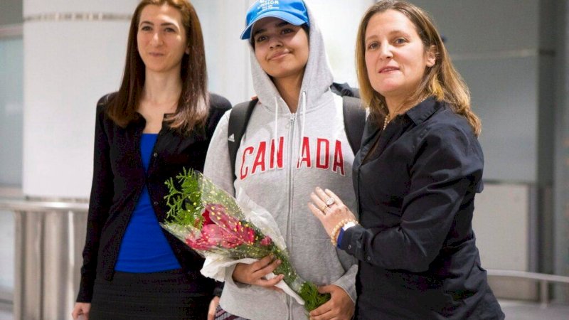 Rahaf Mohammed Alqunun,  (tengah), berdiri dengan Menteri Luar Negeri Kanada Chrystia Freeland (kanan) ketika ia tiba di Bandara Internasional Toronto Pearson, pada hari Sabtu, 12 Januari 2019.  (Chris Young / The Canadian Press via AP)
