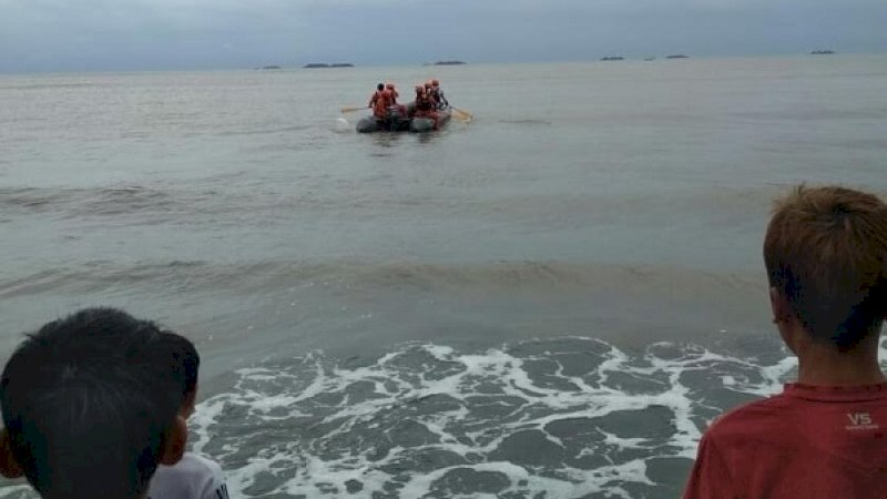 Anak kecil melihat Tim Basarnas bergegas ke tengah dengan perahu karet. Mencari Irpan, pemancing yang menghilang.