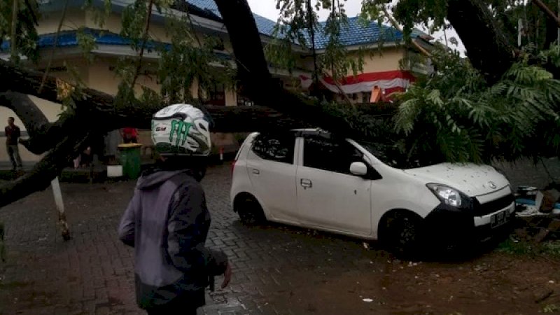 Pohon besar tumbang, menimpa sebuah mobil di halaman RSUD Syekh Yusuf, Gowa.