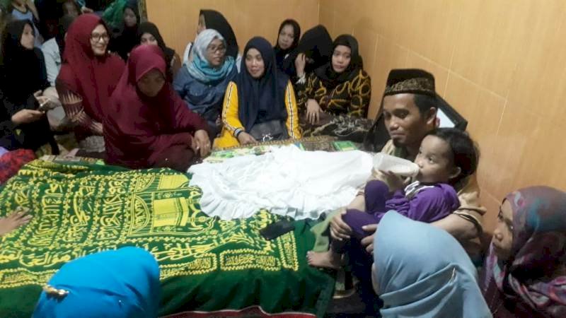 Ustaz Maulana menggendong anaknya di rumah duka