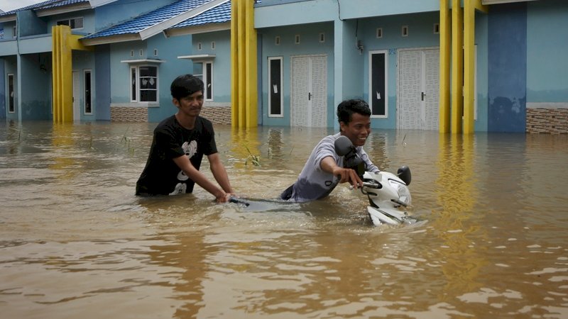 Para warga Kecamatan Manggala, Antang, berusaha mengevakuasi motor, Kamis (24/01/2019). Foto/Arfa Ramlan.

