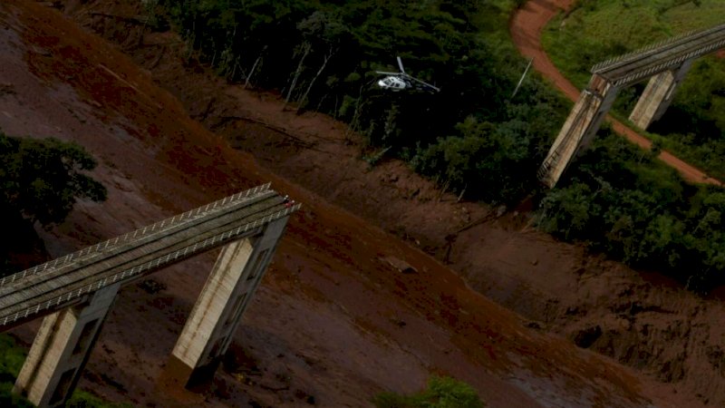 Sebuah helikopter terbang di atas daerah di mana bendungan milik penambang Brasil Vale SA runtuh, di Brumadinho, Brasil, 25 Januari 2019. (Reuters)