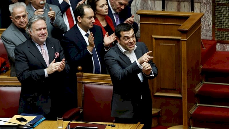 Perdana Menteri Yunani Alexis Tsipras dan anggota pemerintahnya bertepuk tangan setelah pemungutan suara pada Perjanjian Prespes [Costas Baltas / Reuters]