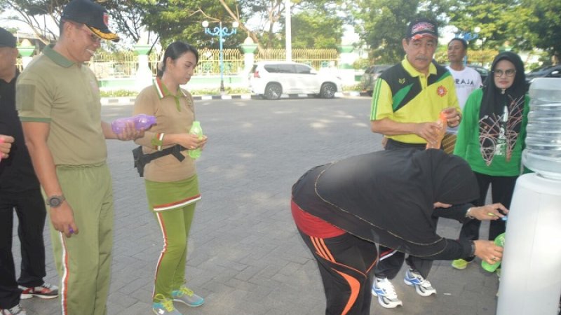 Bupati Sidrap Dollah Mando antre untuk mengambil air minum pada dispenser di pelataran Monumen Ganggawa, Sidrap, Jumat (1/2/2019).