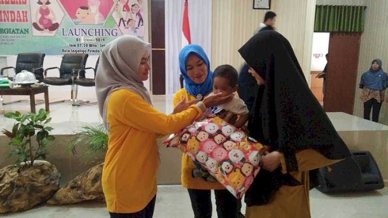 Bupati Luwu Utara, Indah Putri Indriani memberikan hadiah kepada seorang bayi laki-laki korban gempa dan tsunami Palu.