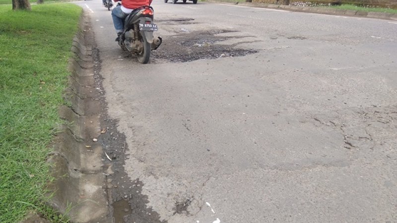 Jalan Metro Tanjung Bunga, Makassar yang rusak parah setelah hujan mendera Makassar. 