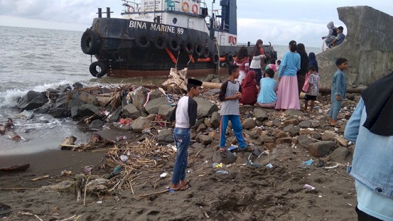 Sebuah kapal yang terdampar di pesisir pantai Takalar. Kapal ini menjadi pusat perhatian warga setempat.