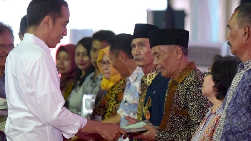 Presiden Joko Widodo saat menyerahkan sertifikat tanah beberapa waktu lalu. (FOTO: DOK SETKAB)