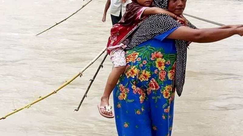 Warga melintas di jembatan tali kabel di Desa Sikundo, Kecamatan Pantai Ceureumen, Kabupaten Aceh Barat.