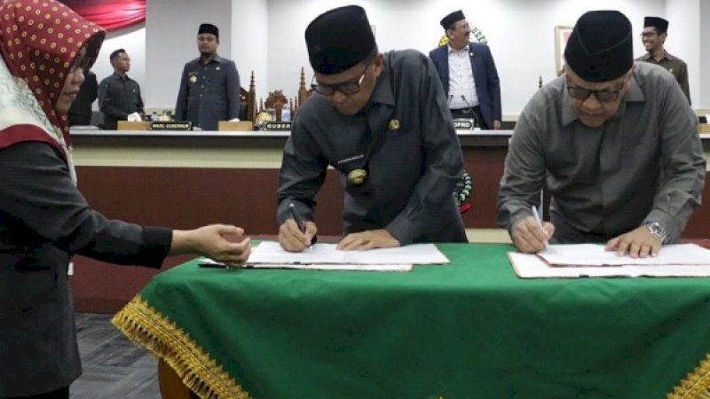 Gubernur Sulsel, Nurdin Abdullah dan Ketua DPRD Sulsel HM Roem, saat menandatangani 3 ranperda yang telah disepakati.