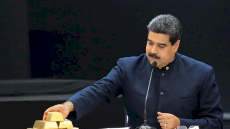 Presiden Venezuela Nicolas Maduro menyentuh batangan emas ketika ia berbicara selama pertemuan dengan para menteri yang bertanggung jawab atas sektor ekonomi di Istana Miraflores di Caracas, Venezuela 22 Maret 2018 (Reuters)