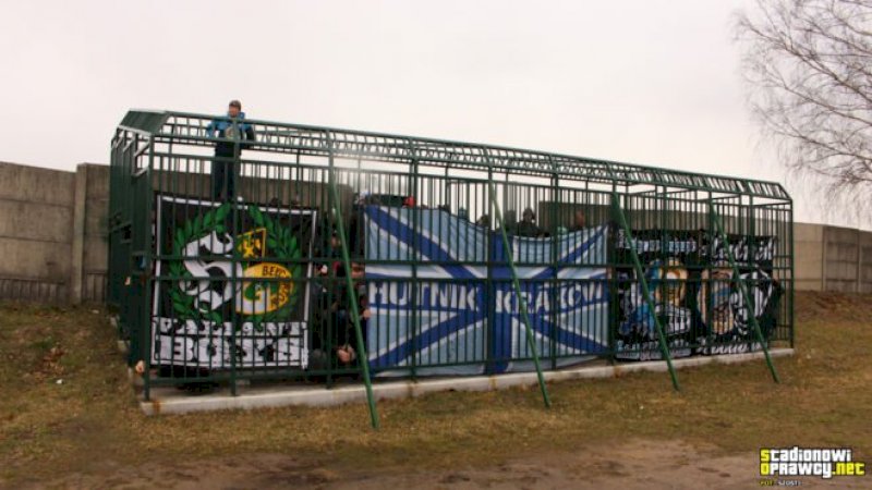 Para penggemar menonton pertandingan di dalam kandang logam