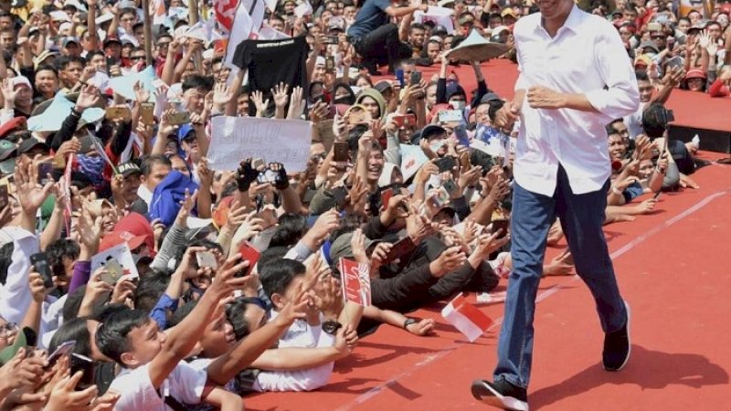 Jokowi berlari-lari kecil di atas panggung kampanye di Stadion 17 Mei Banjarmasin, Rabu (27/3/2019).