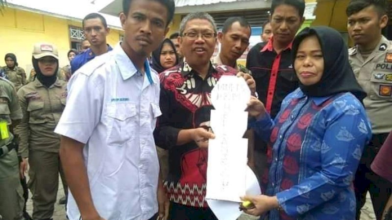 Aktivis KNPI menyerahkan nisan kayu ke ketua.