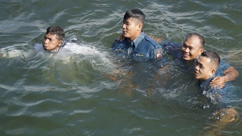 Prajurit Lantamal VI yang naik pangkat, terjun ke laut sebagai bagian dari ritual di Angkatan Laut.