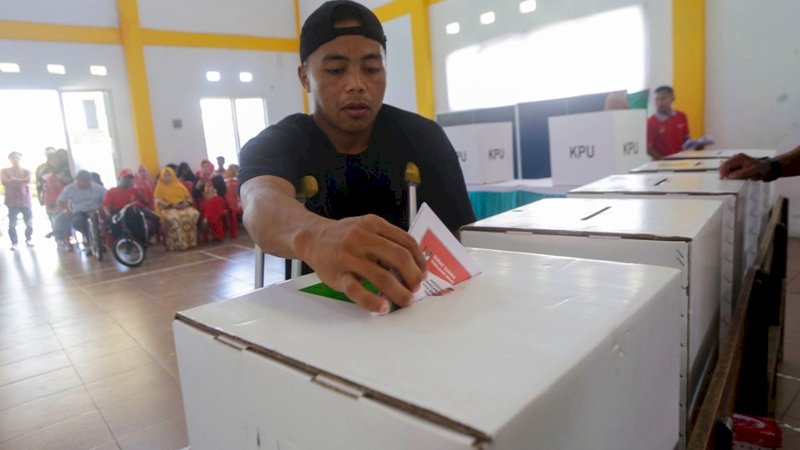 Penyandang disabilitas saat memasukkan surat suara ke dalam kotak suara Pemilu 2019 di Kota Makassar, Rabu (17/4/2019). Foto: Arfa