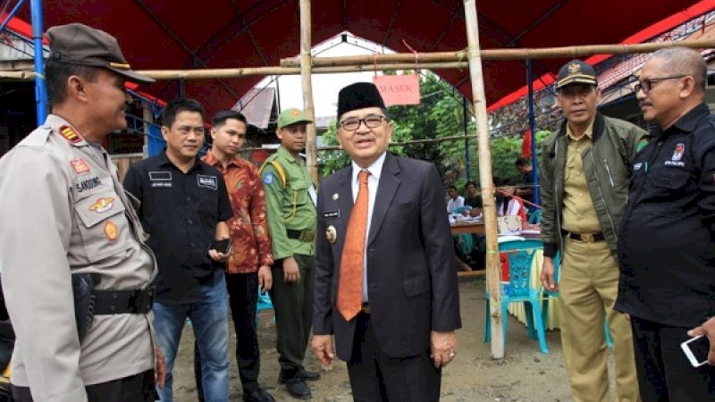Wali Kota Palopo, HM Judas Amir, berbincang-bincang dengan penyelenggara di salah satu TPS yang menggelar PSU.
