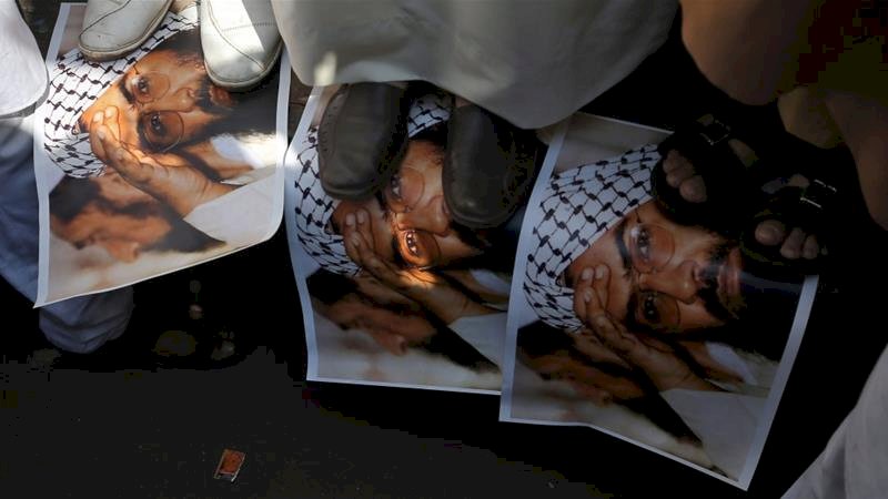 Demonstran India menginjak poster Masood Azhar, kepala kelompok Jaish-e-Muhammad, pada bulan Februari (Francis Mascarenhask / Reuters).