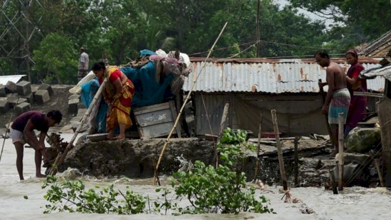 Orang-orang mencoba memperbaiki rumah mereka yang rusak di Khulna, Bangladesh (Getty)