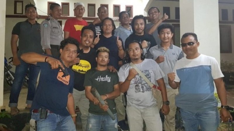 Tersangka Joni, (kedua kiri), saat diamankan polisi.