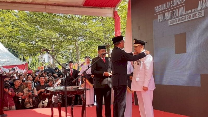 Nurdin Abdullah menyematkan tanda pangkat ke pundak Penjabat Wali Kota Makassar, Iqbal Suhaeb, dalam pelantikan, Senin, 13 Mei 2019.