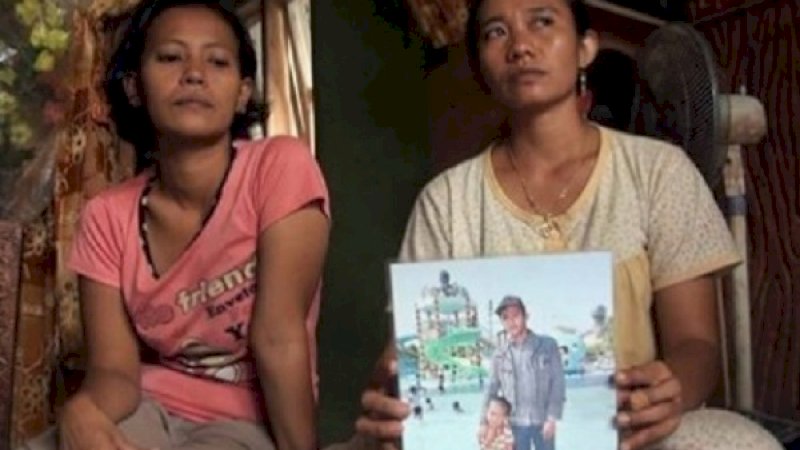 Istri Eko, Lili (kanan), memperlihatkan foto korban semasa hidup.