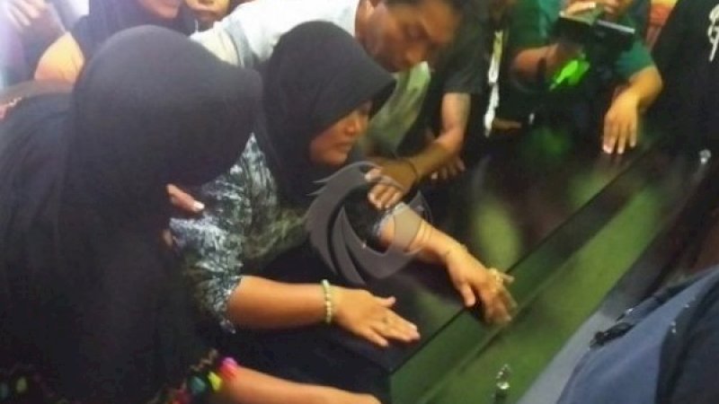 Laili Fitria menangisi jasad suaminya di peti mati. (Sumber foto: Faktualnews).