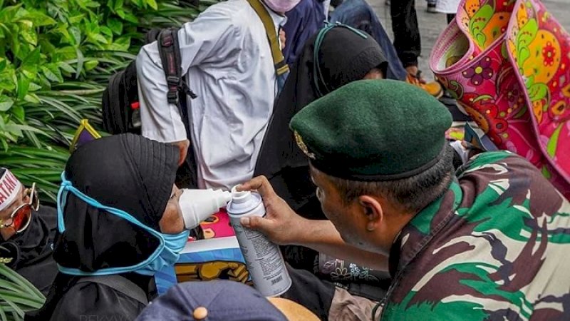 Personel TNI menolong seorang pengunjuk rasa yang terkena gas air mata, Rabu (22/5/2019).