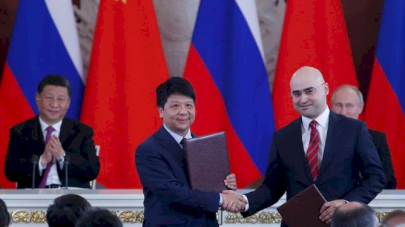 Wakil Ketua Huawei Guo Ping berjabat tangan dengan Presiden MTS Alexei Kornya (Getty Images)