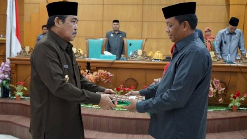 Ketua DPRD Sidrap, Zulkifli Zain, menyerahkan dua perda yang telah ditetapkan kepada Bupati Sidrap, Dollah Mando, dalam sdiang paripurna, Jumat, 21 Juni 2019.