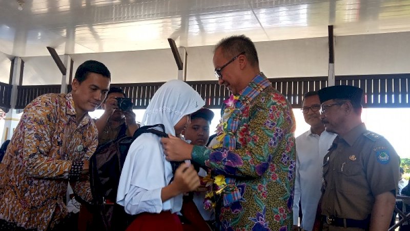 Menteri Sosial RI Agus Gumiwang Kartasasmita (kanan) saat membagikan ransel kepada siswa dalam kunjungannya ke Kabupaten Gowa, Selasa (16/7/2019).