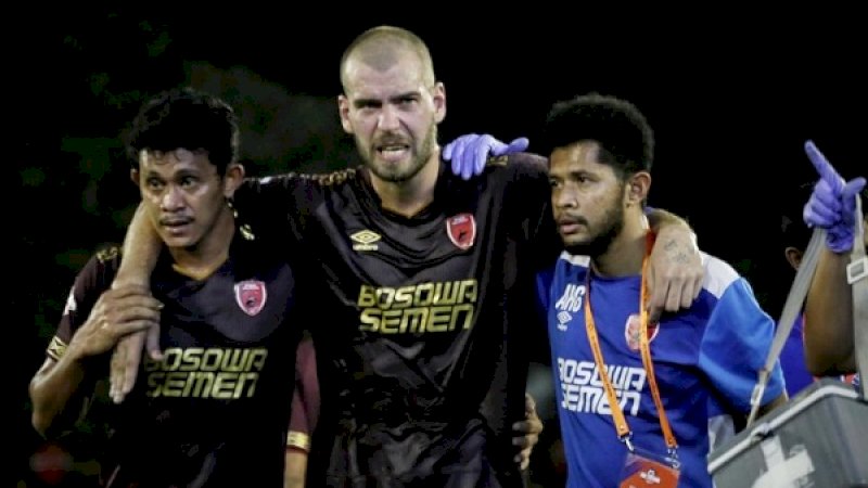 Wiljan Pluim (tengah), tampak meringis kesakitan saat dipapah Rizky Pellu dan seorang tim medis PSM, dalam laga melawan Persebaya di Stadion Andi Mattalatta, Rabu malam. (Foto: Arfa Ramlan/Rakyatku.com)