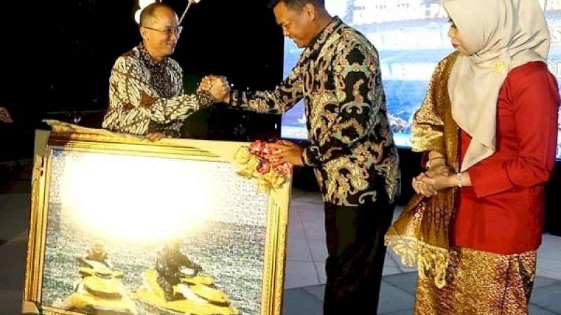 Laksma TNI Dwi Sulaksono (tengah) dan istri, mendapat cenderamata berupa lukisan.