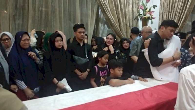 Adnan Purichta Ichsan dipeluk salah seorang kerabatnya, di depan peti jenazah ayahandanya, Ichsan Yasin Limpo, malam tadi.