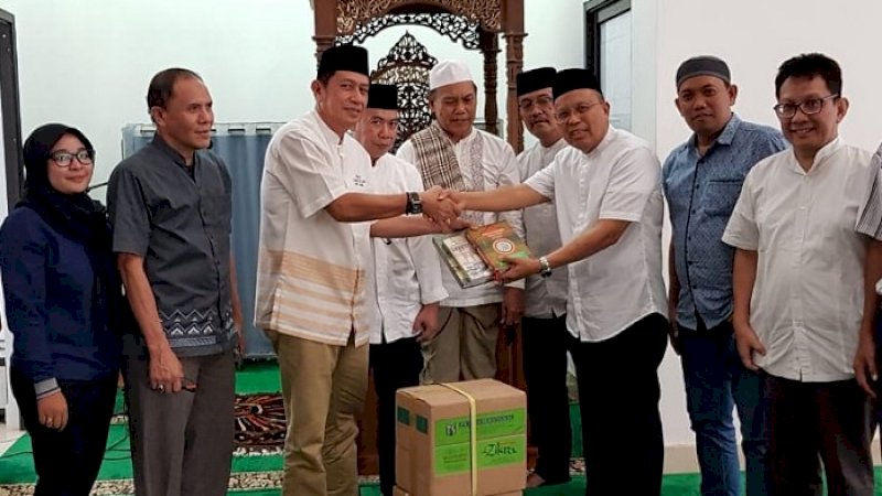 Ketua MUI Sulsel Bidang Infokom, Waspada Santing menyerahkan mushaf Alquran pengurus Masjid Nurul Yasin PWI Sulsel, Jumat (2/8/2019).