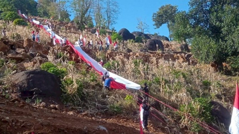 Prosesi pembentangan bendera 400 meter di Bukit Tokka Tena Rata, Desa Tompobulu, Kecamatan Moncongloe Kabupaten Maros, Sabtu (17/8/2019).