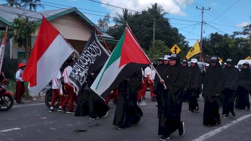 Foto peserta gerak jalan indah mengenakan pakaian hitam seragam syar'i dengan membawa tiga bendera jadi perbincangan.
