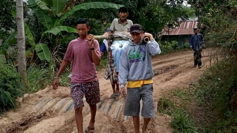 Medan yang sulit membuat Daeng Geseng (65) terpaksa ditandu untuk berobat ke Puskesmas.