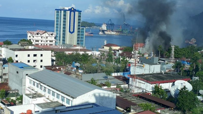 Asap mengepul dari salah satu bangunan yang dibakar massa dalam aksi protes yang berujung anarkis di Jayapura, Kamis (29/8/2019).(KOMPAS.com)