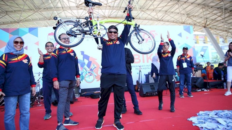 Penjabat Wali Kota Makassar, Iqbal Suhaeb sempat mengangkat sepeda lipat Brompton yang menjadi hadiah utama.