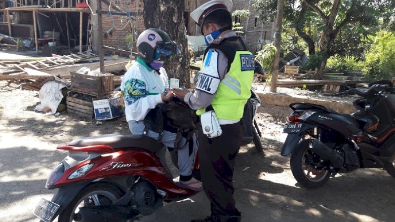 Polisi memeriksa kelengkapan surat kendaraan salah seorang pengendara, Senin (2/9/2019).