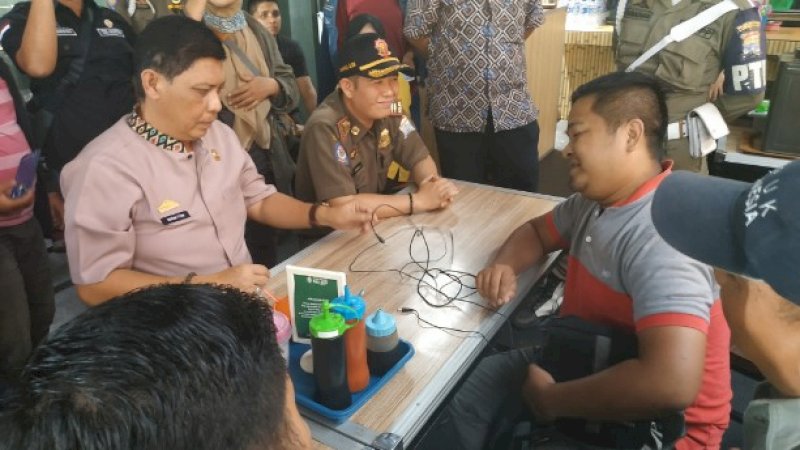 Petugas BPPD Palembang berdialog dengan Azis, pemilik warung bakso Granat.