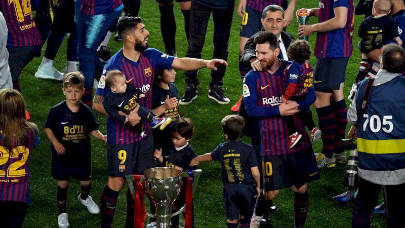 Luis Suarez dan Lionel Messi merayakan gelar La Liga 2018-2019 di Camp Nou bersama buah hati mereka, Minggu dini hari WIB (28/4/2019). (AFP/Lluis Gene)