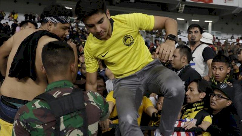 Suporter Malaysia dievakuasi petugas usai laga Indonesia v Malaysia.
